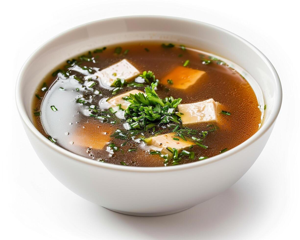 a bowl of soup with tofu and herbs photo