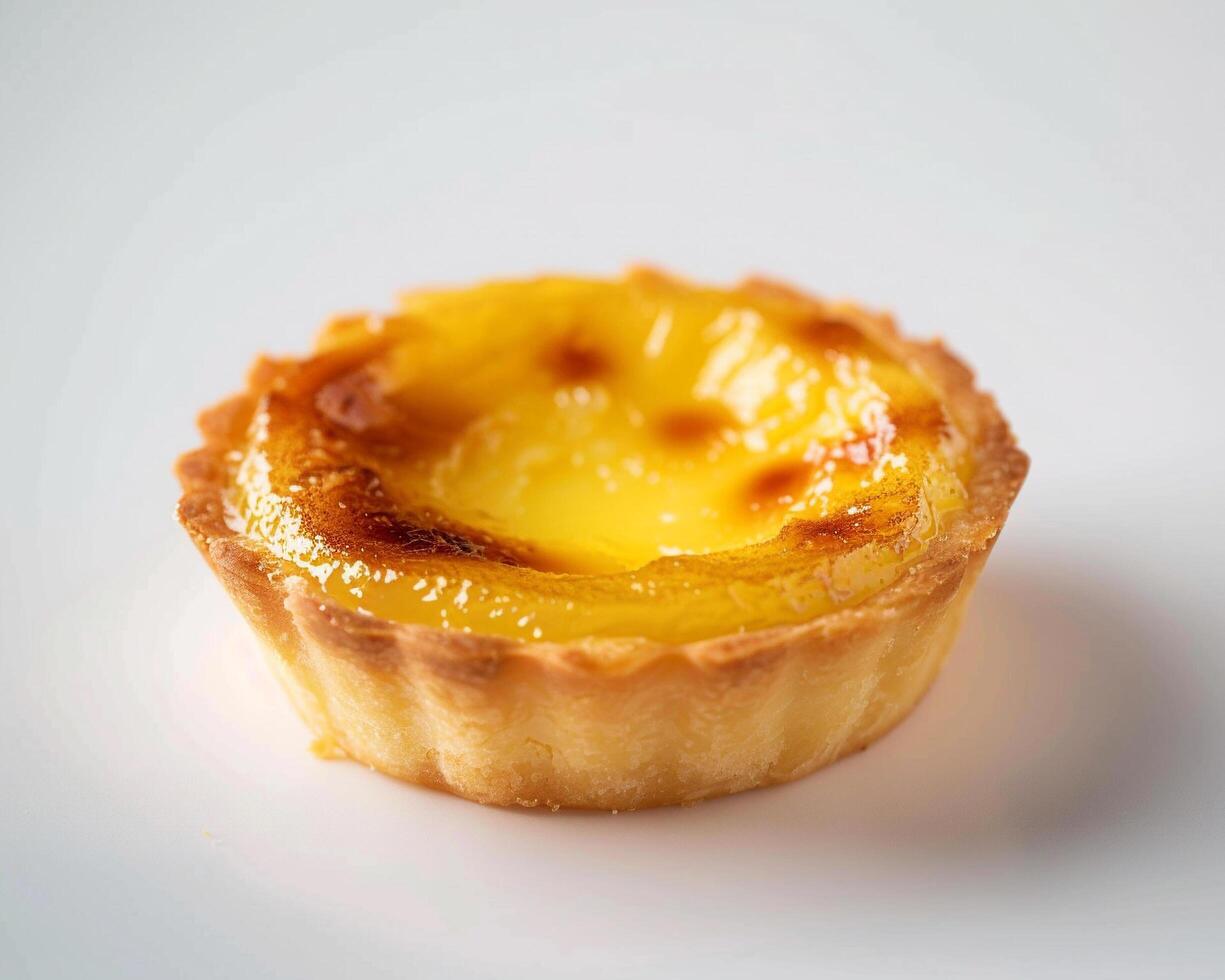 A small pastry with a yellow top on a white surface photo