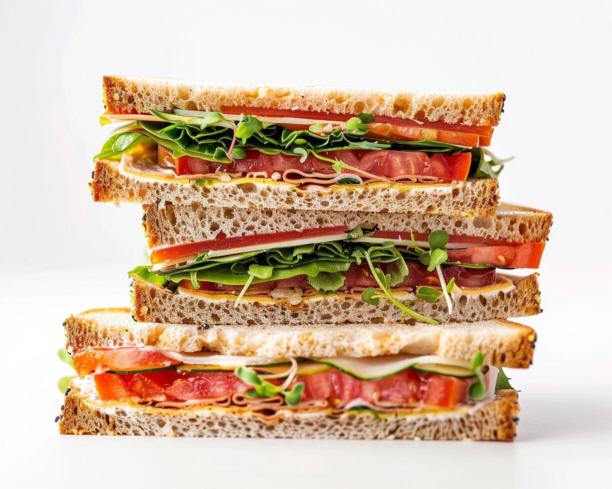 a stack of three sandwiches on a white surface photo