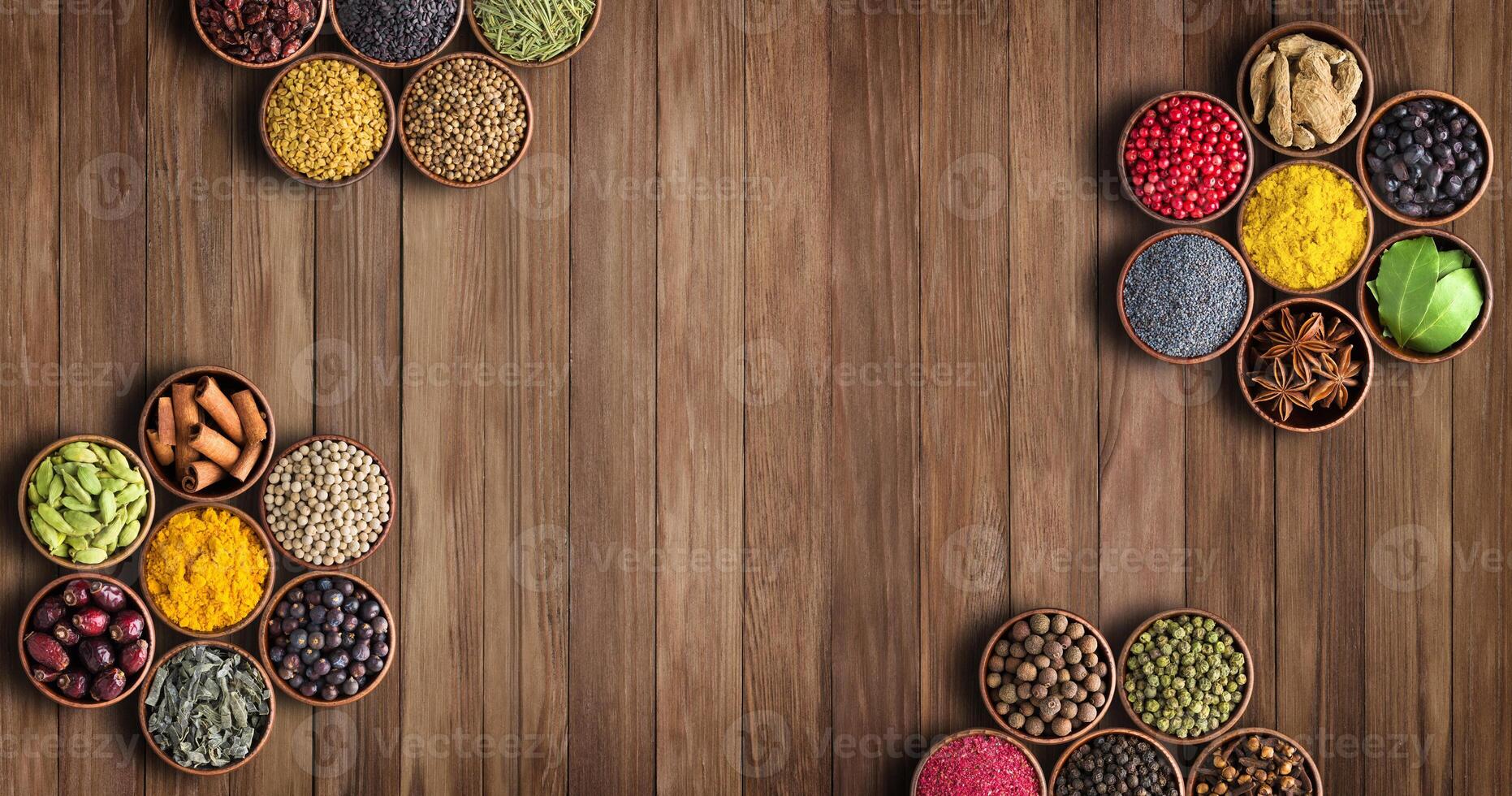 Spices on a wooden table, top view. Seasoning with empty space photo