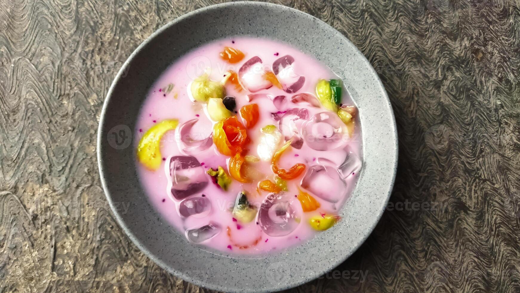 Es buah or sop buah-is an Indonesian iced fruit cocktail dessert. This cold and sweet beverage is made of diced fruits mixed with shaved ice or ice cubes, and sweetened with liquid sugar or syrup. photo