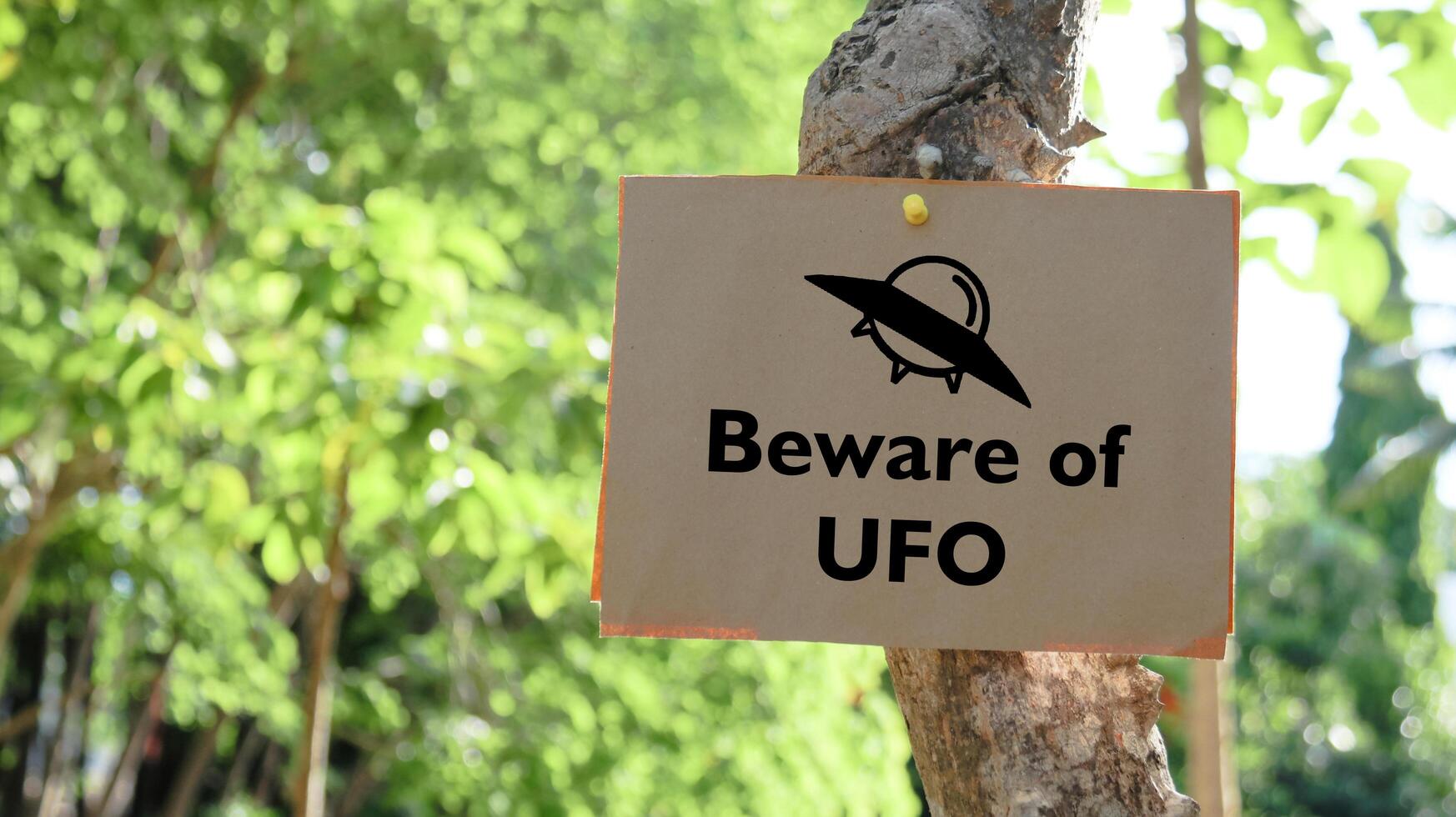 Illustrated with a black UFO space ship the paper sign prominently displays the words Beware of UFO. photo