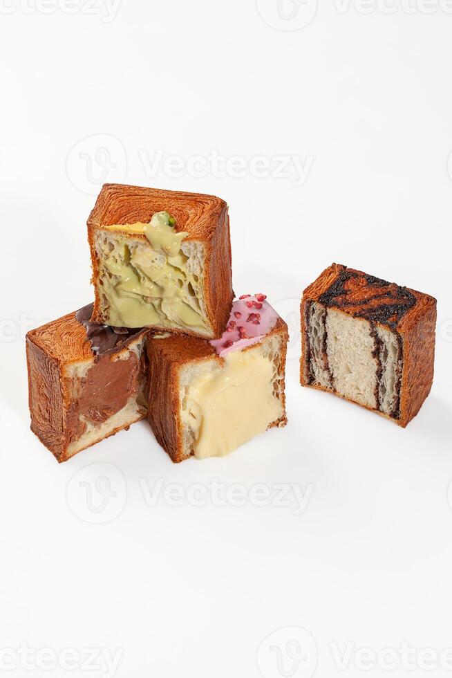 Halves of sweet croissants cubes with various fillings isolated on white background photo