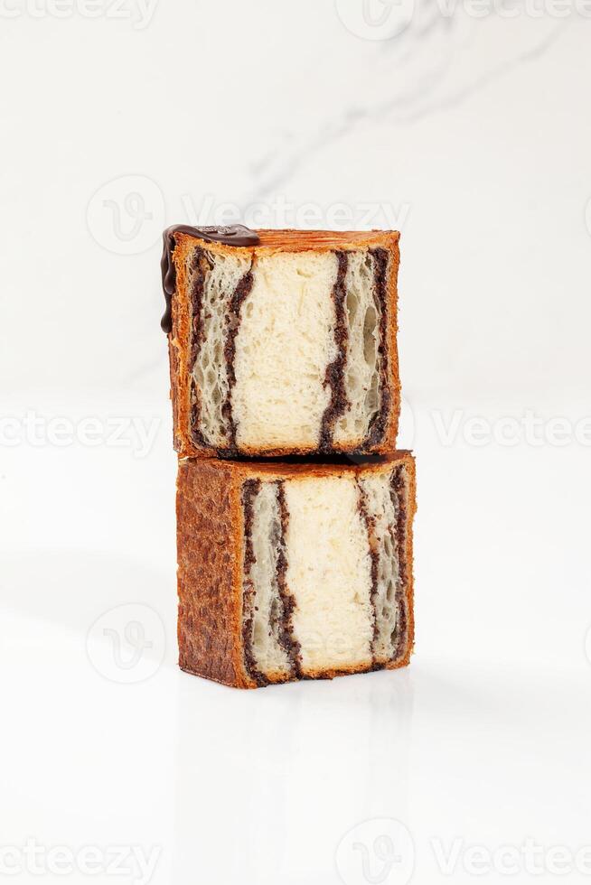 Sliced puff pastry cube shaped croissant with chocolate walnut layer photo