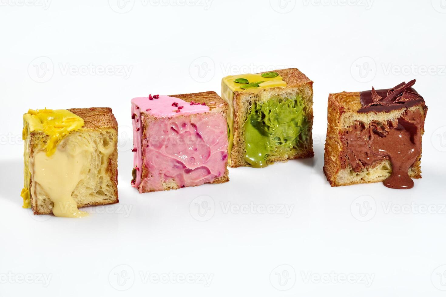 Cubed croissant halves with fillings of vanilla and berry custard, pistachio and chocolate cream photo