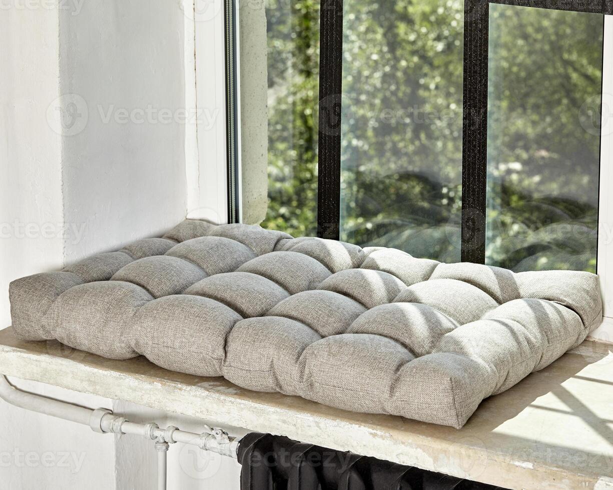 Soft Scandinavian style gray cushion lying on windowsill photo