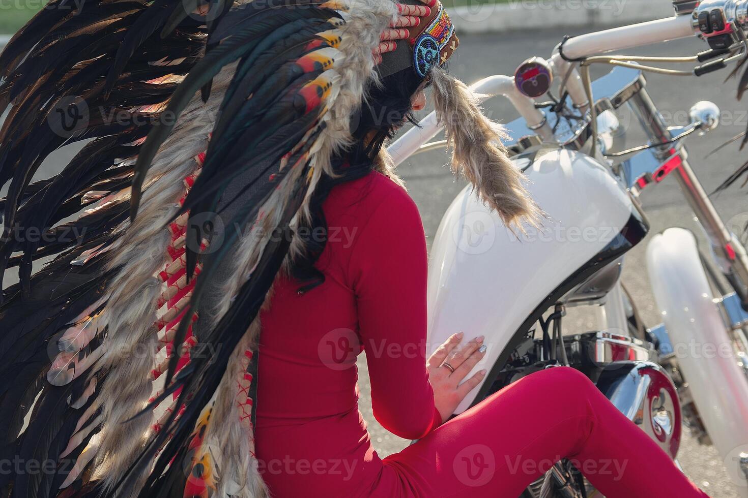 A girl in an Indian costume sits on a retro motorcycle. Transport photo