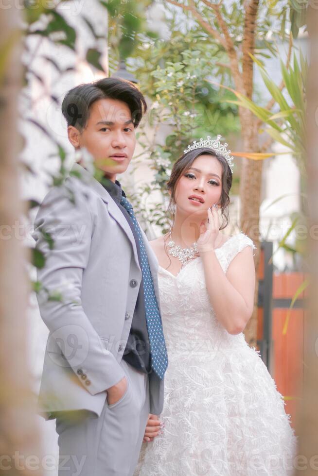 a pair of men and women pose elegantly where men and women look glamorous wearing beautiful dresses in a park, national bride outdoor wedding couple photo