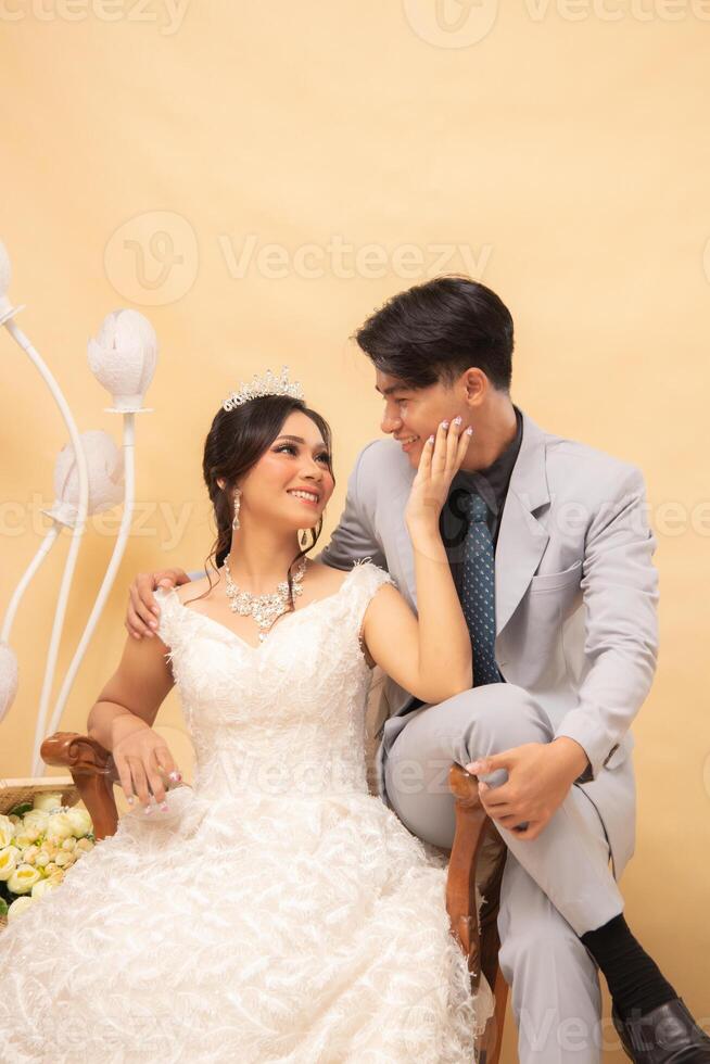 elegant male and female couple poses sitting standing relaxed all smiling spoiled looking forward intimately indoor photo shot close up. couple wedding national bride studio