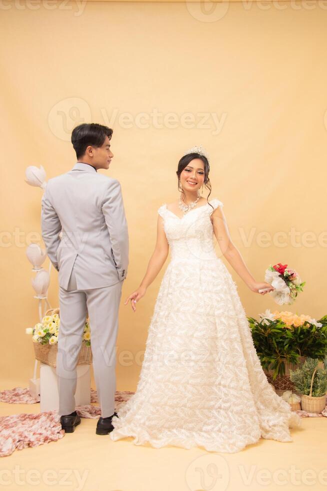 beauty of male and female couples standing poses casually laughing looking at the front of the woman and the man with their backs to each other intimately indoor photo shot. couple wedding