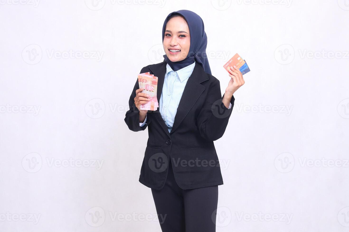 asian office executive woman in hijab standing happy carrying money and debit credit card aside. adult muslim blue shirt for business, transactions and loans photo