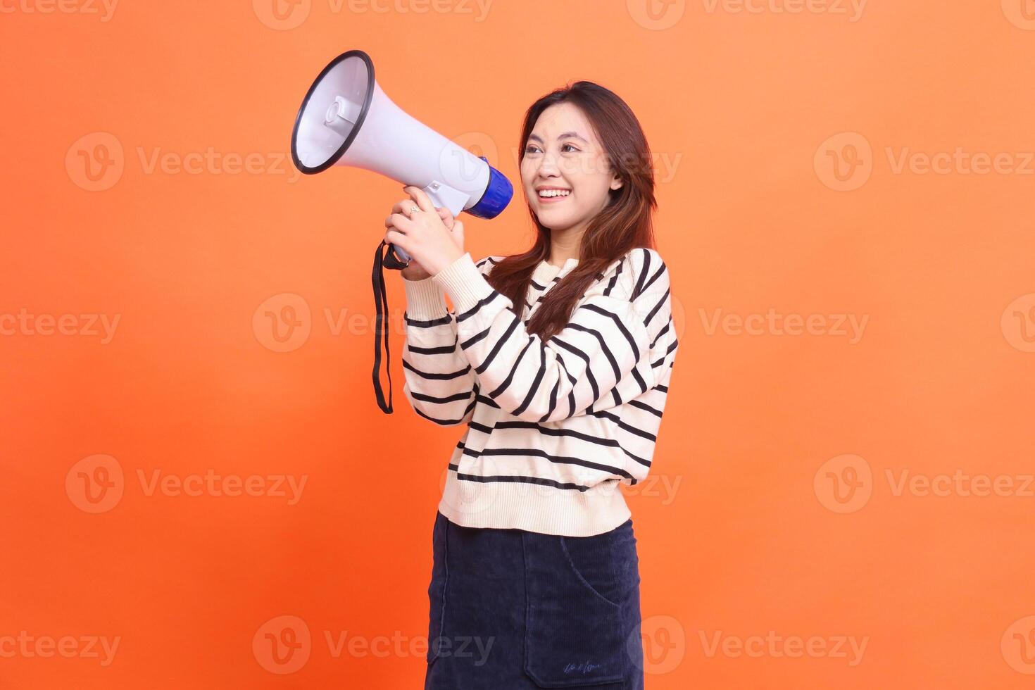 Asian woman candid smile shouting expression standing with two hands holding megaphone loudspeaker for warning. for fashion, business and broadcast concepts photo