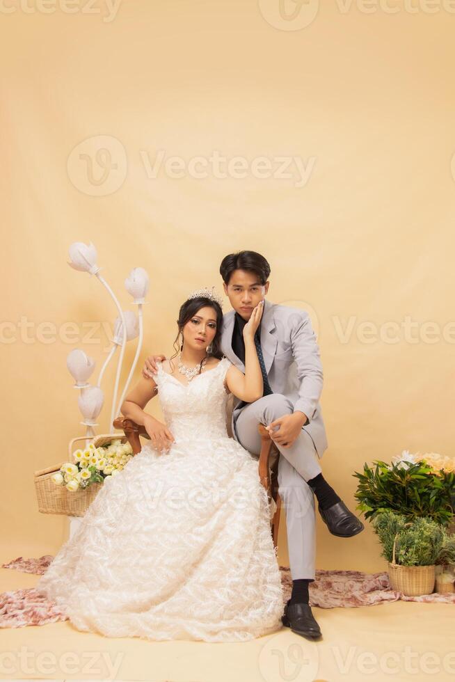 elegant male and female couple poses sitting standing relaxed all smiling spoiled looking forward intimately indoor photo shot. couple wedding national bride studio