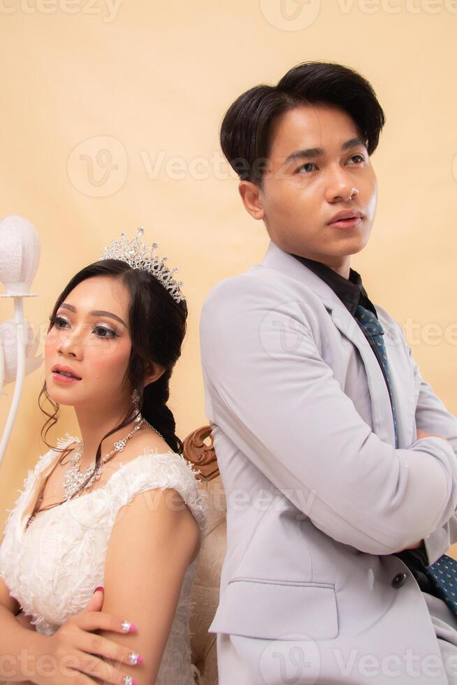 elegant male and female couple standing poses relaxed smiling slightly looking forward lovingly repelled indoor photo shot close up. couple wedding national bride studio