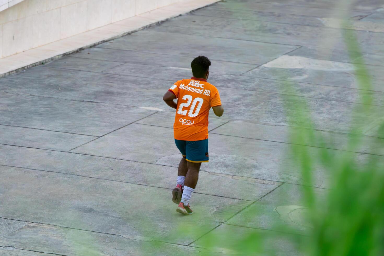 Jakarta, Indonesia, 2024 - Morning Exercise, Running Man in Lapangan Banteng Wearing Jersey photo