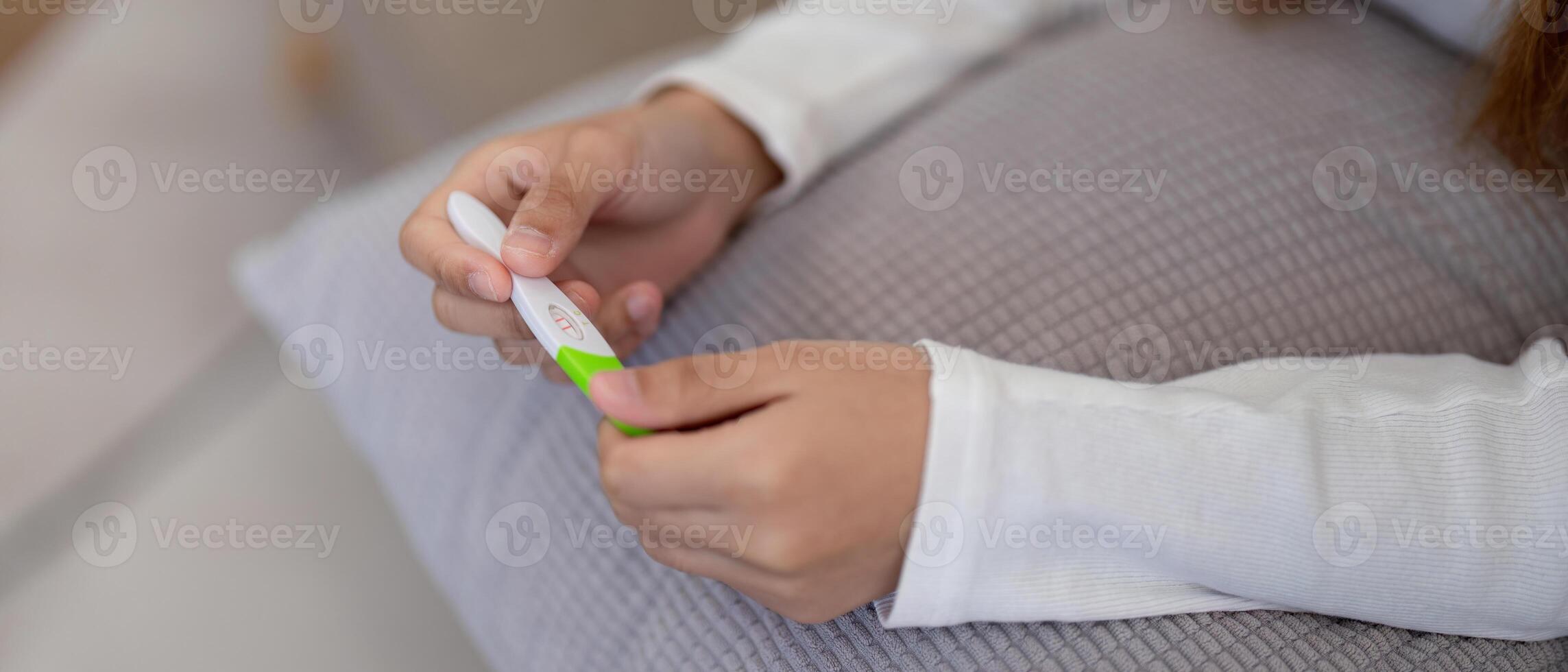 Woman examining pregnancy test results with concern. Concept of personal health, anxiety, and reproductive issues photo