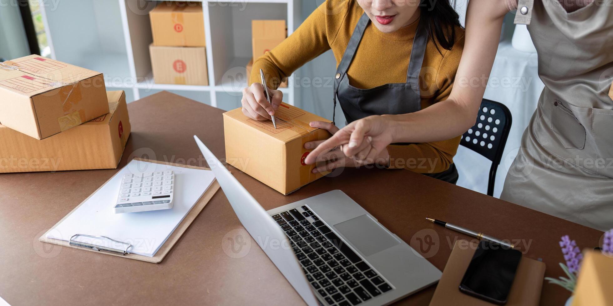 Asian women managing shipping logistics for online business. Concept of e-commerce operations, teamwork, and order fulfillment photo