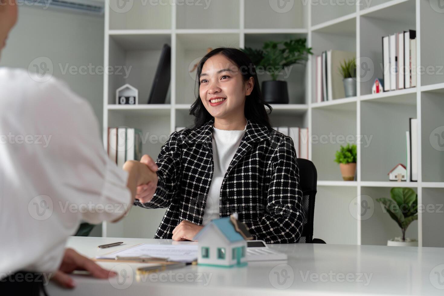 Real estate agents and customers shake hands to congratulate on signing a contract to buy a house with land and insurance, handshake and good response concept photo