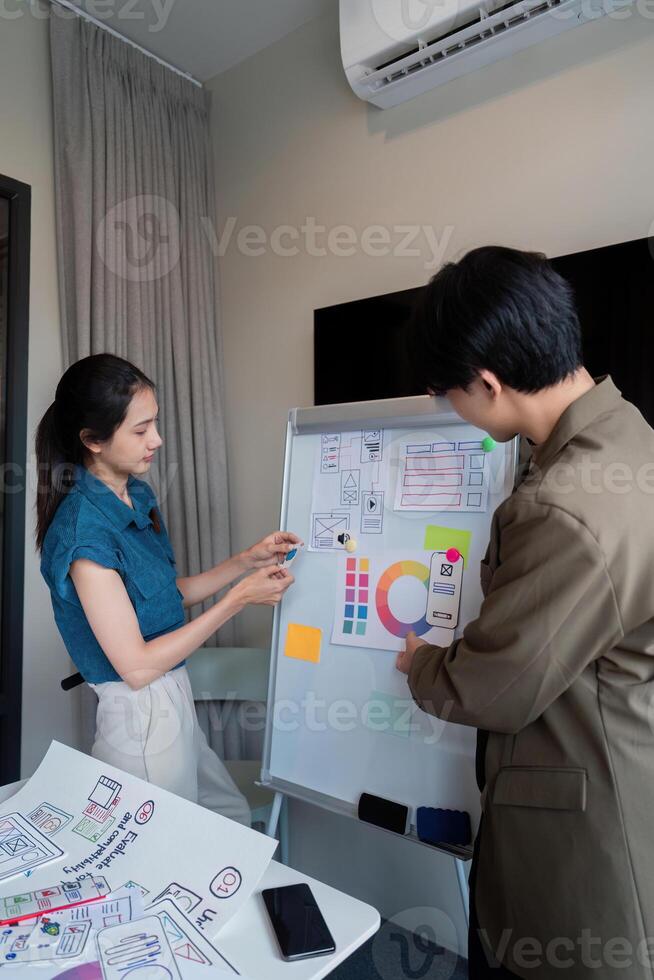 ux developer and ui designer presenting mobile app interface design on whiteboard in meeting at office. Creative digital development mobile app agency. digital transformation photo