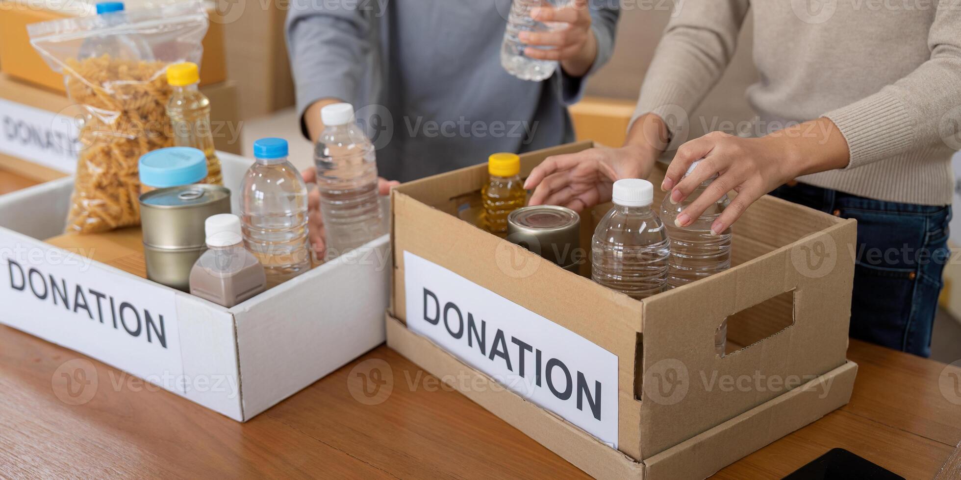 Group of volunteer woman working in home. Happy volunteer looking at food donation box separating donations stuffs photo