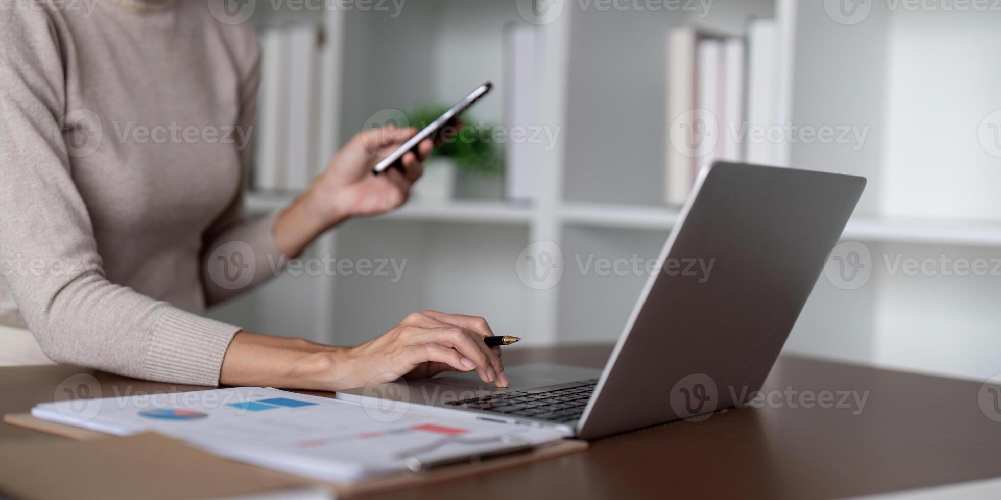 Businesswoman using laptop computer and working at office with calculator document on desk, doing planning analyzing the financial report, business plan investment, finance analysis concept photo