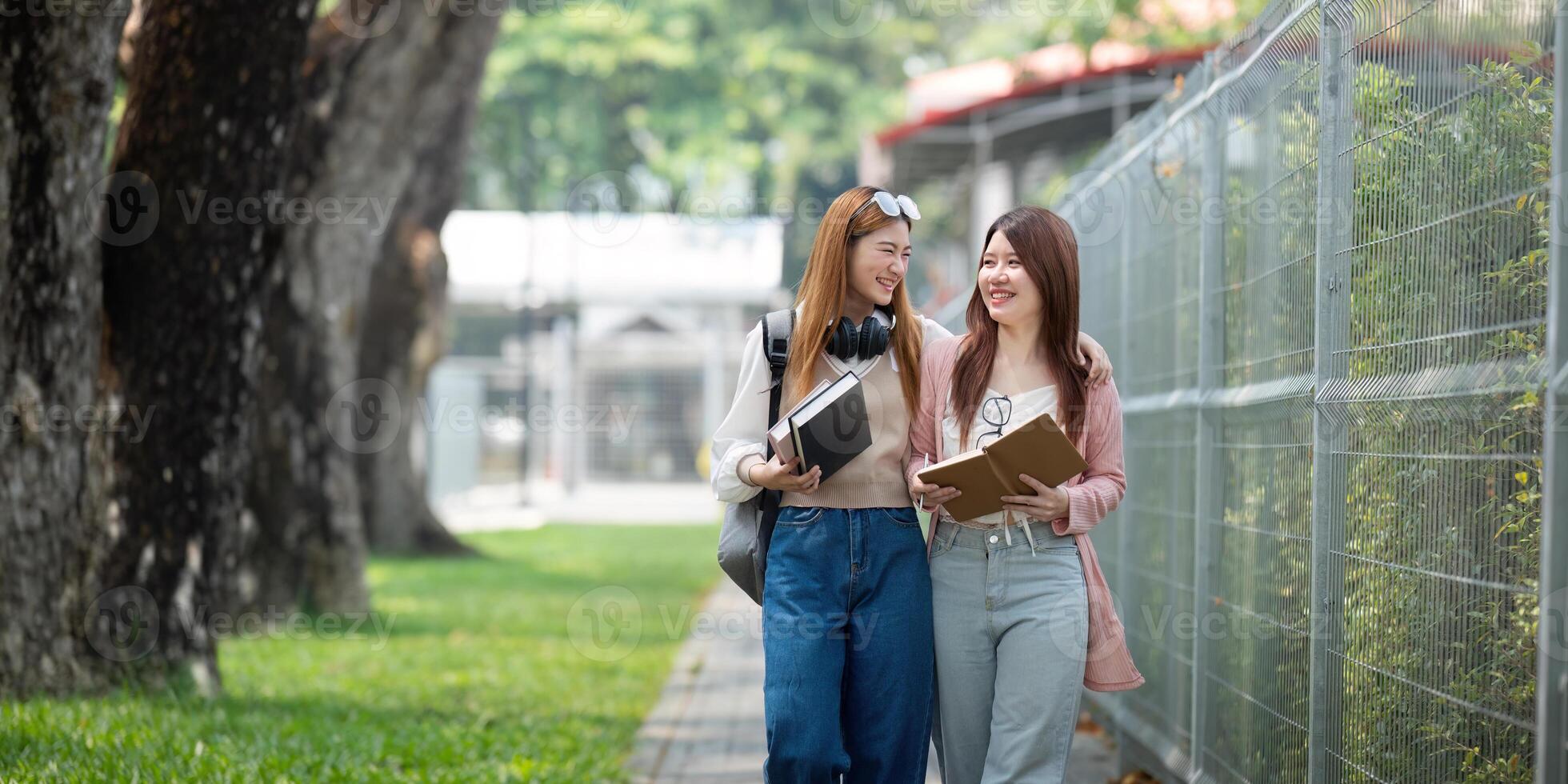 University student girl friends with learning book college while walking in campus photo