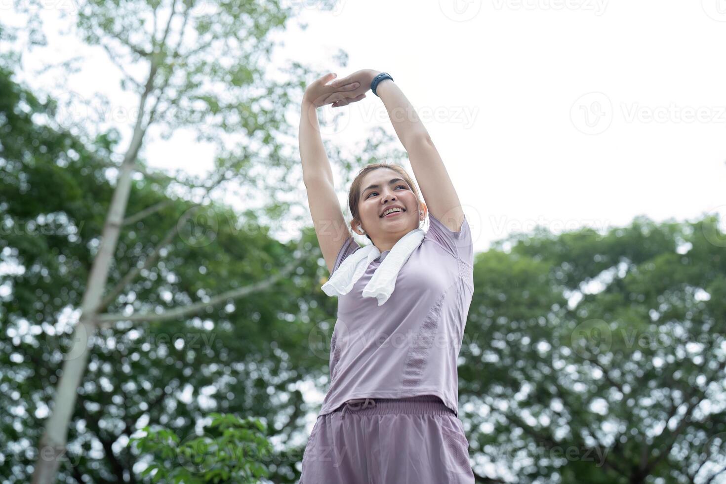 Asian woman stretching after a run in a park photo