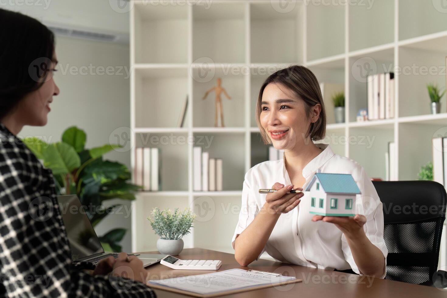 Home sale and home insurance concept, real estate agent with house model talking to client about buy home insurance and client signing contract under formal contract agreement photo