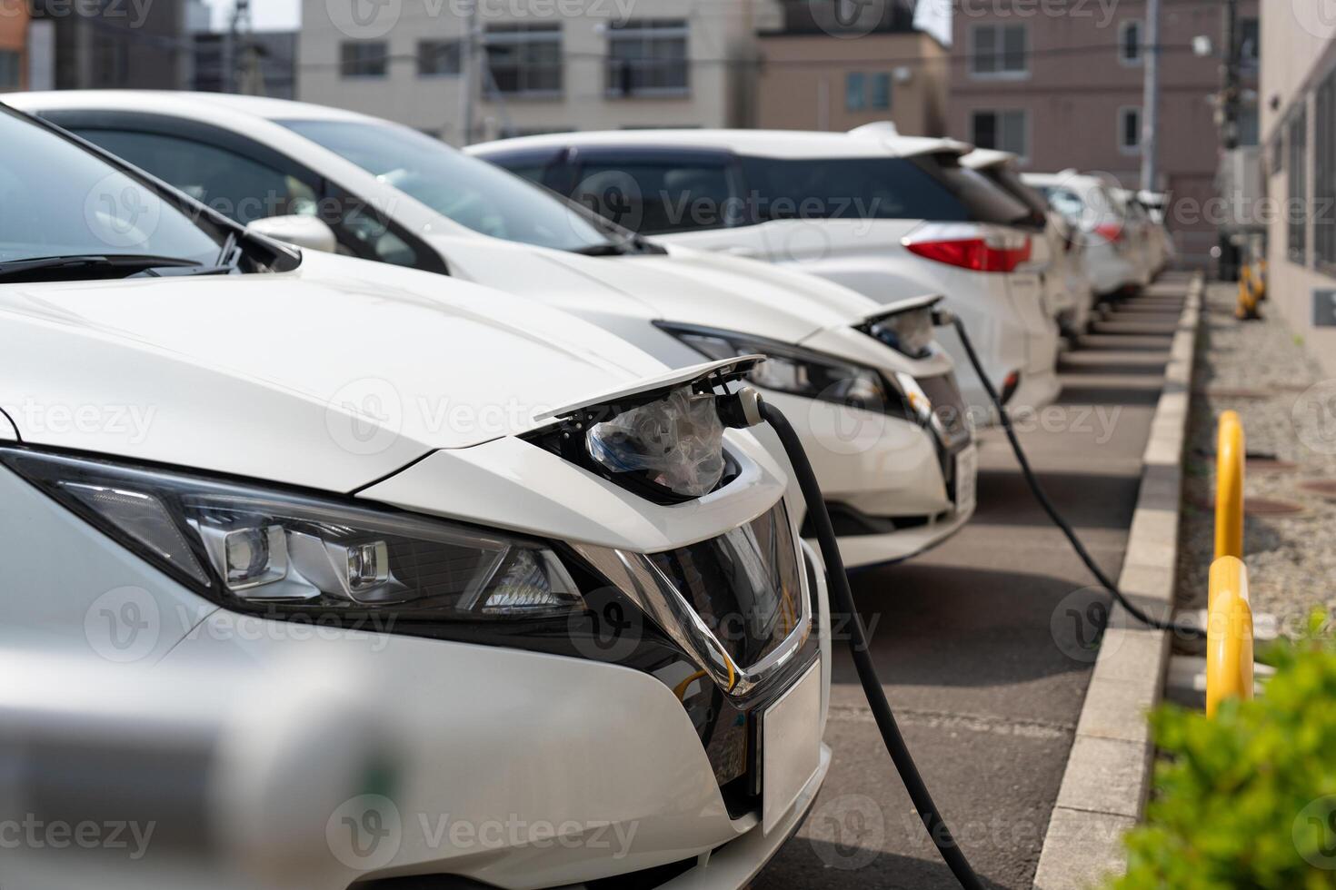 Electric EV car parked in the parking lot while plugged in for charging photo