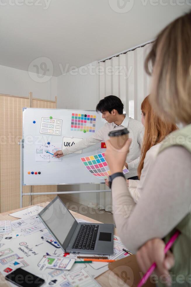 Creative UX Developer and UI Designer Brainstorming Session with Color Palettes and Wireframes in Modern Office photo