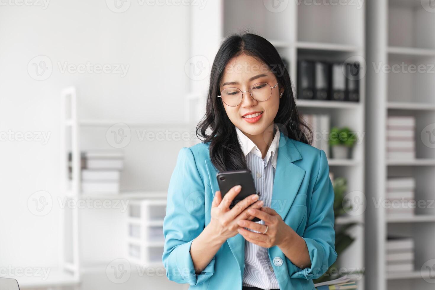 Business woman using mobile phone at a company is typing a conversation on the internet photo