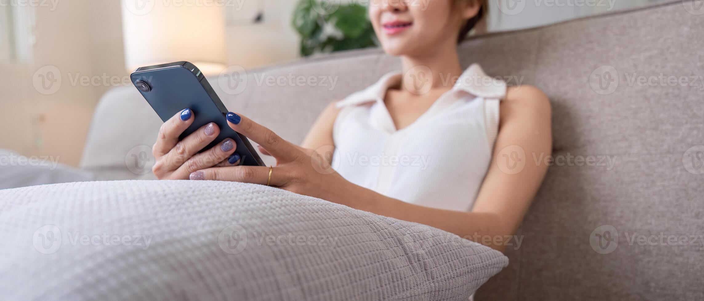 Woman Relax on Couch Using Smartphone for Social Media in Modern Living Room Setting photo
