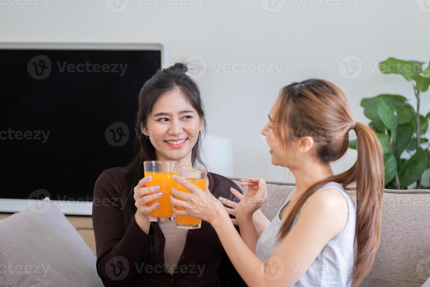 Lesbian Couple Enjoying Healthy Orange Juice Together in Modern Home Setting photo
