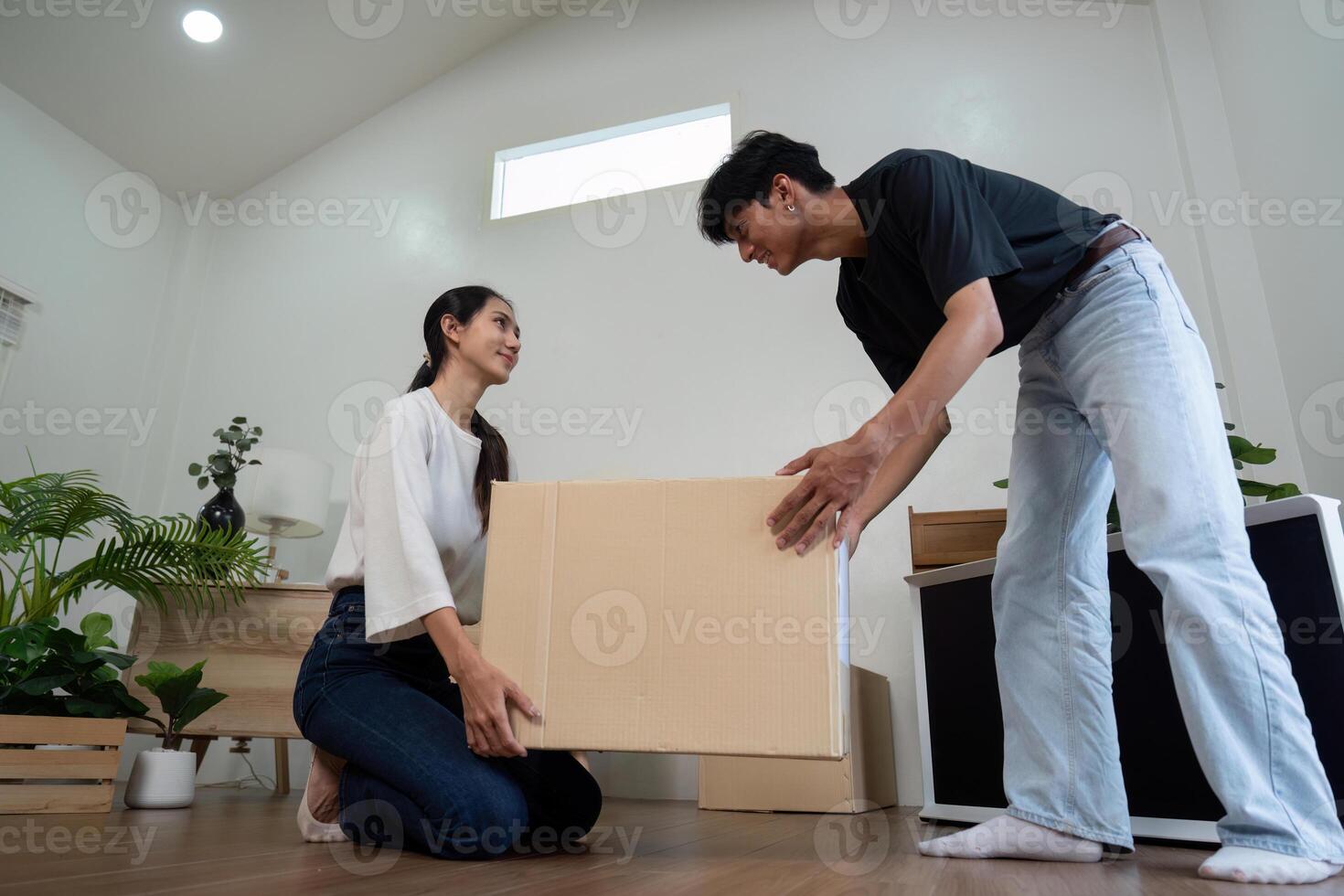 Young Couple Moving into New House, Unpacking Boxes and Setting Up Their Modern Home Together photo