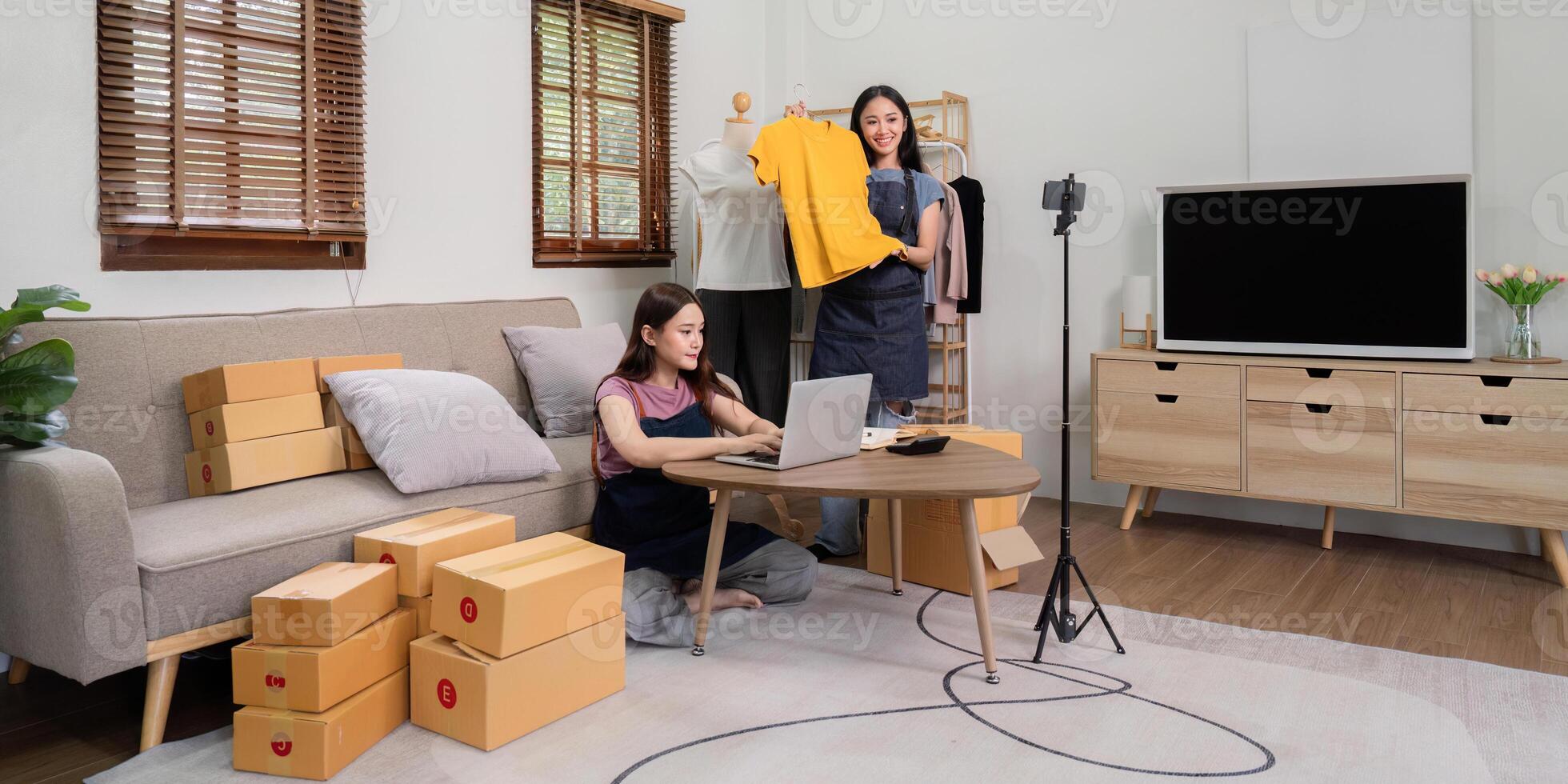 Lesbian Couple Running Online Live Selling Business from Home with Clothing Products and Shipping Boxes photo
