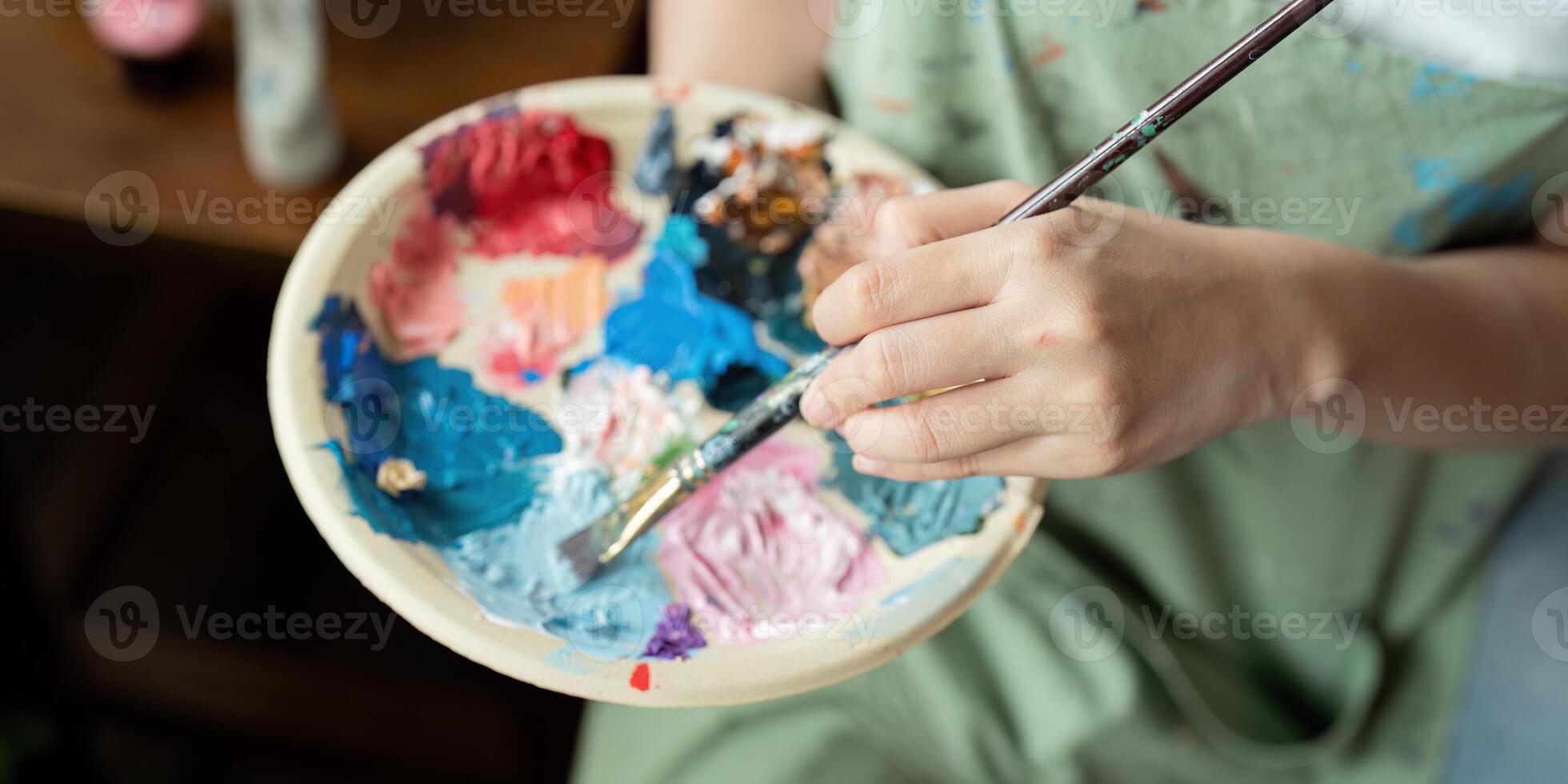 Artist Painting in Workshop with Palette and Brush, Creating Colorful Artwork in Studio, Close Up of Hand and Paints, Creative Process, Artistic Expression, Professional Art Studio Environment photo
