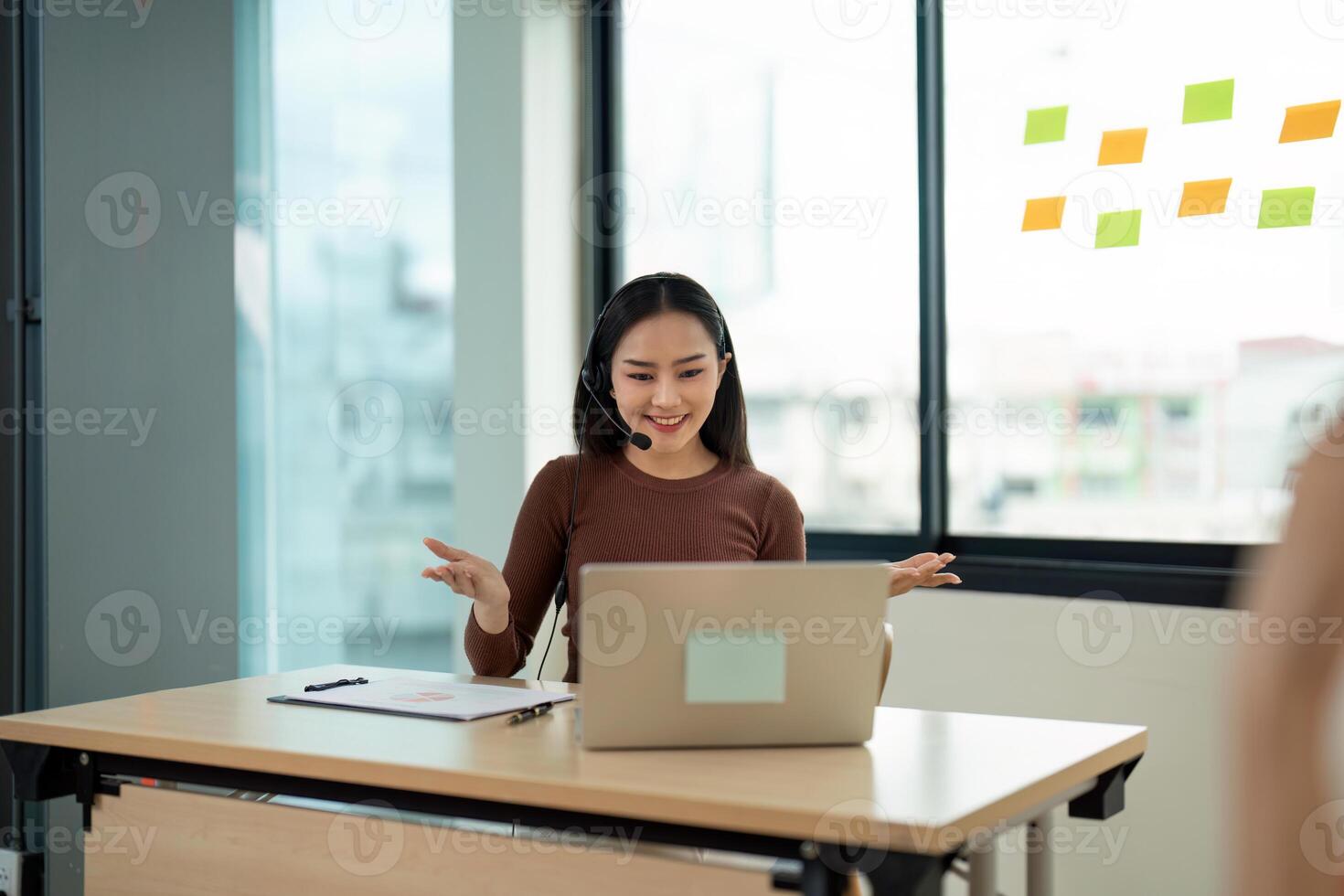Smiling Call Center Agent Working on Laptop with Headset in Modern Office Environment photo