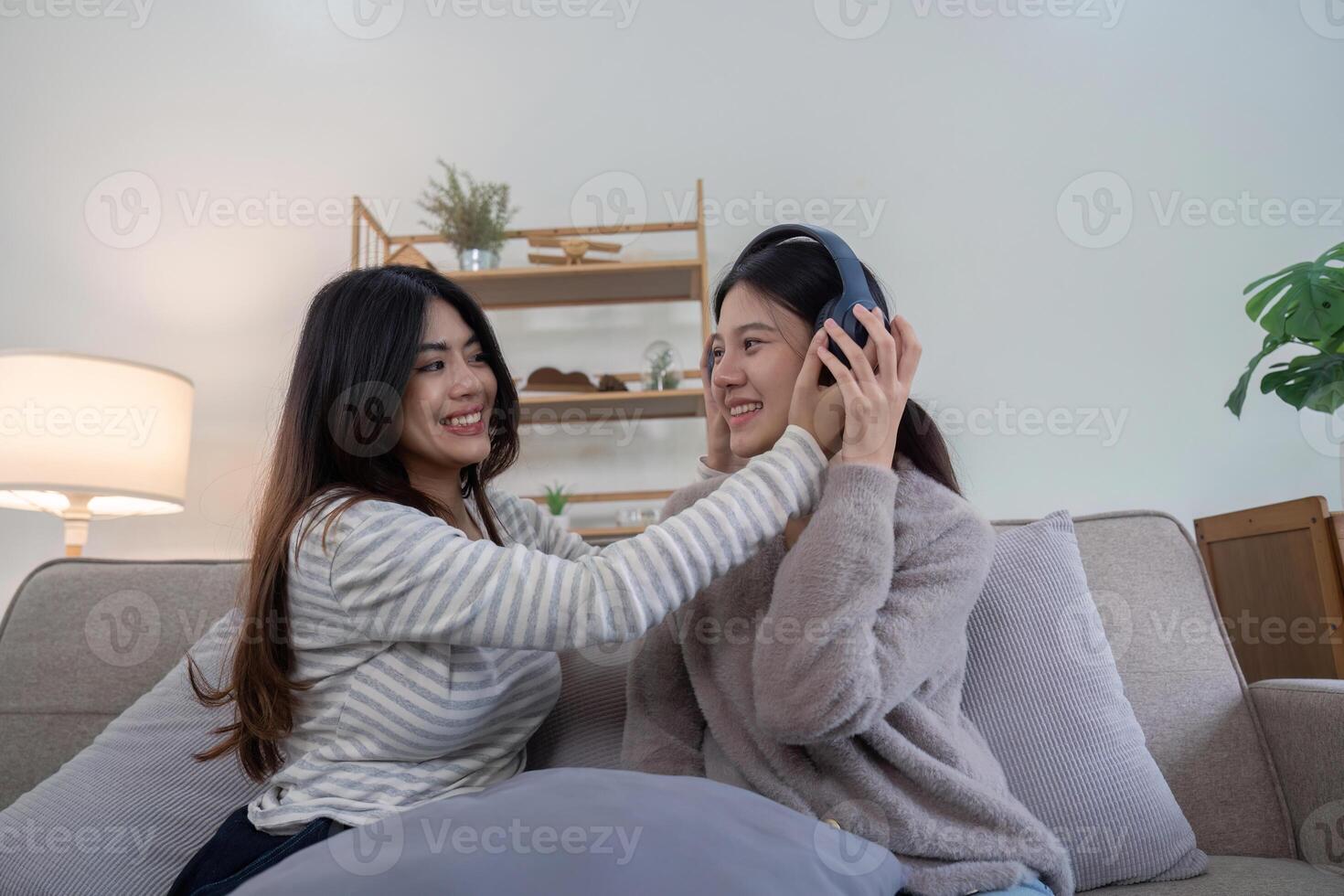 Lesbian Couple Relaxing at Home, Enjoying Quality Time Together on the Couch, Listening to Music and Sharing a Happy Moment photo