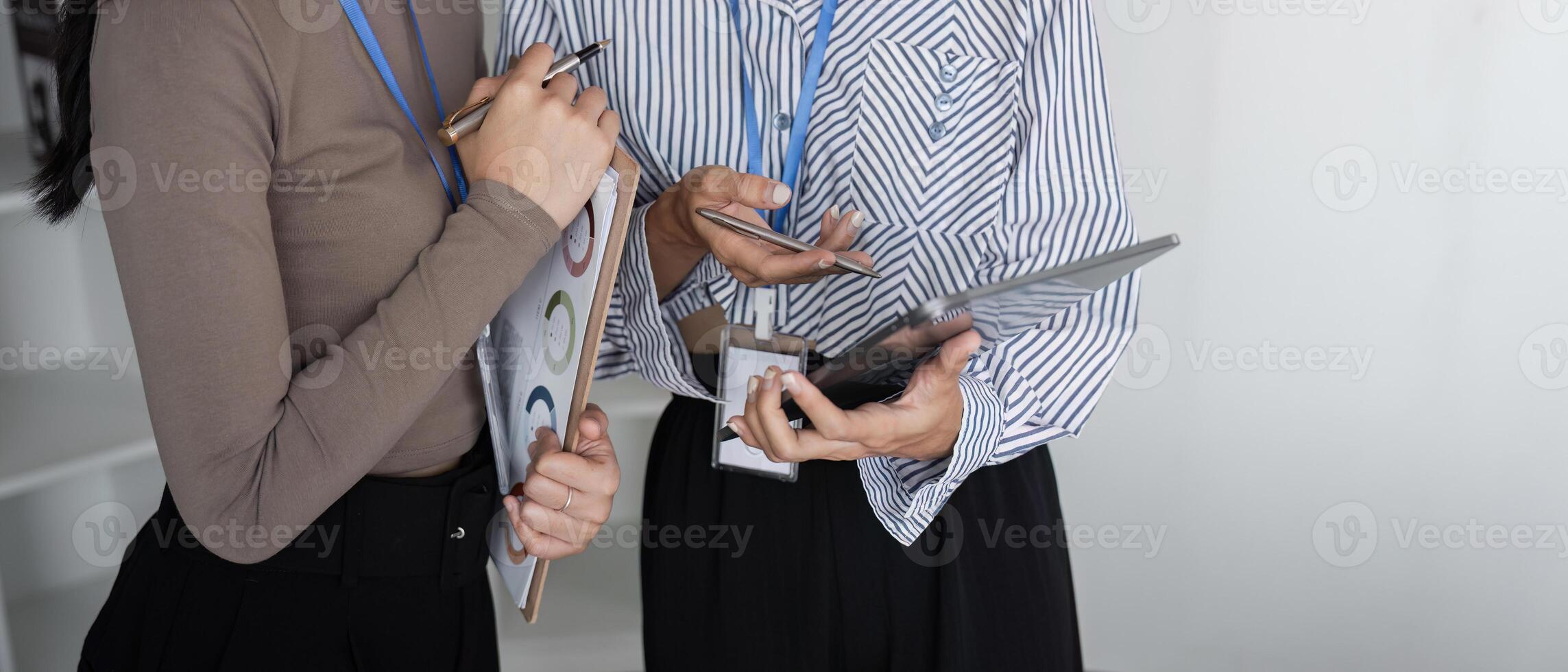 Two Business Professional Discussing Planning and Analysis with Documents and Digital Devices in a Modern Office Setting photo
