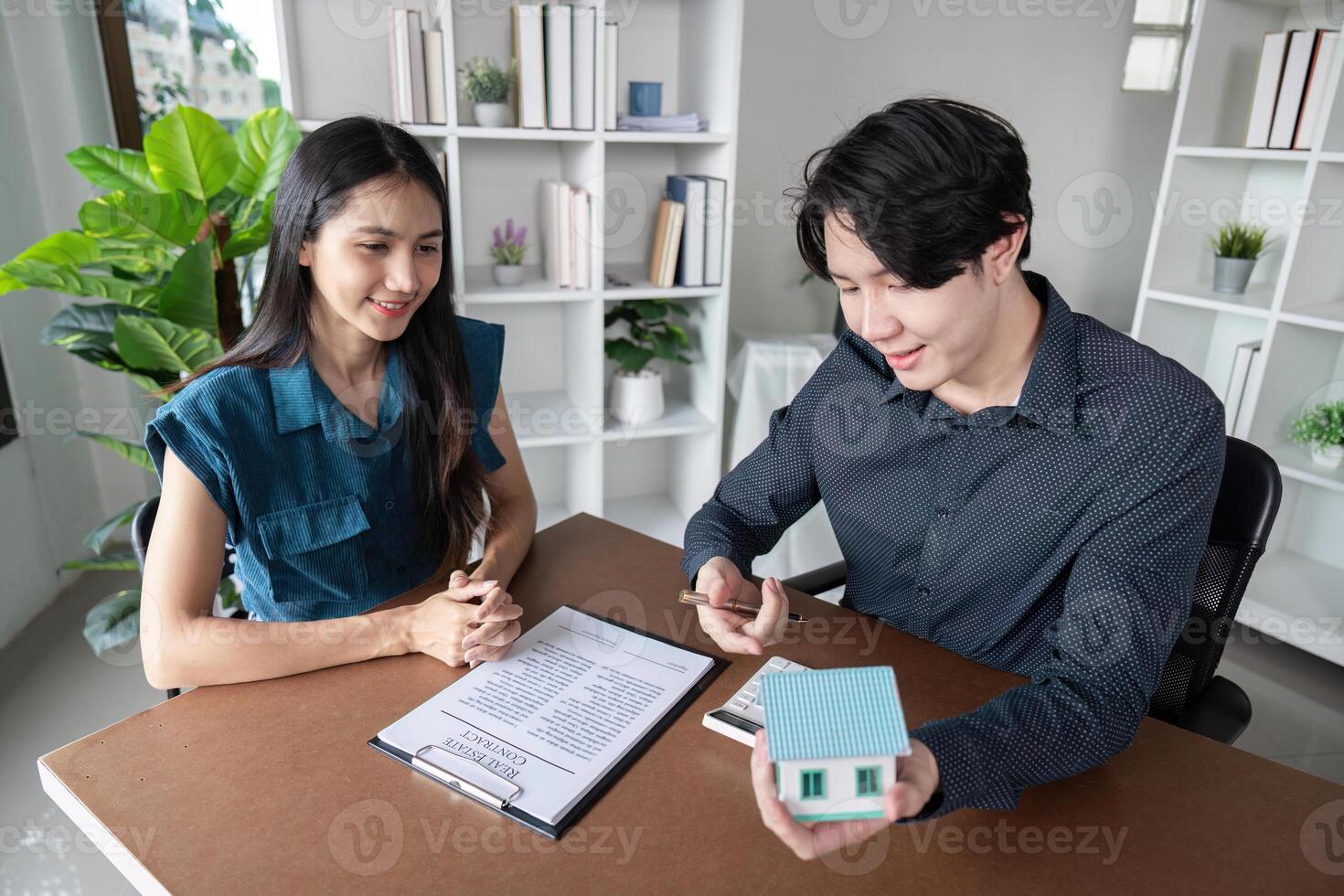 Real Estate Agent Buy Sell Contract Signing with Happy Clients and Agent in Modern Office Environment photo