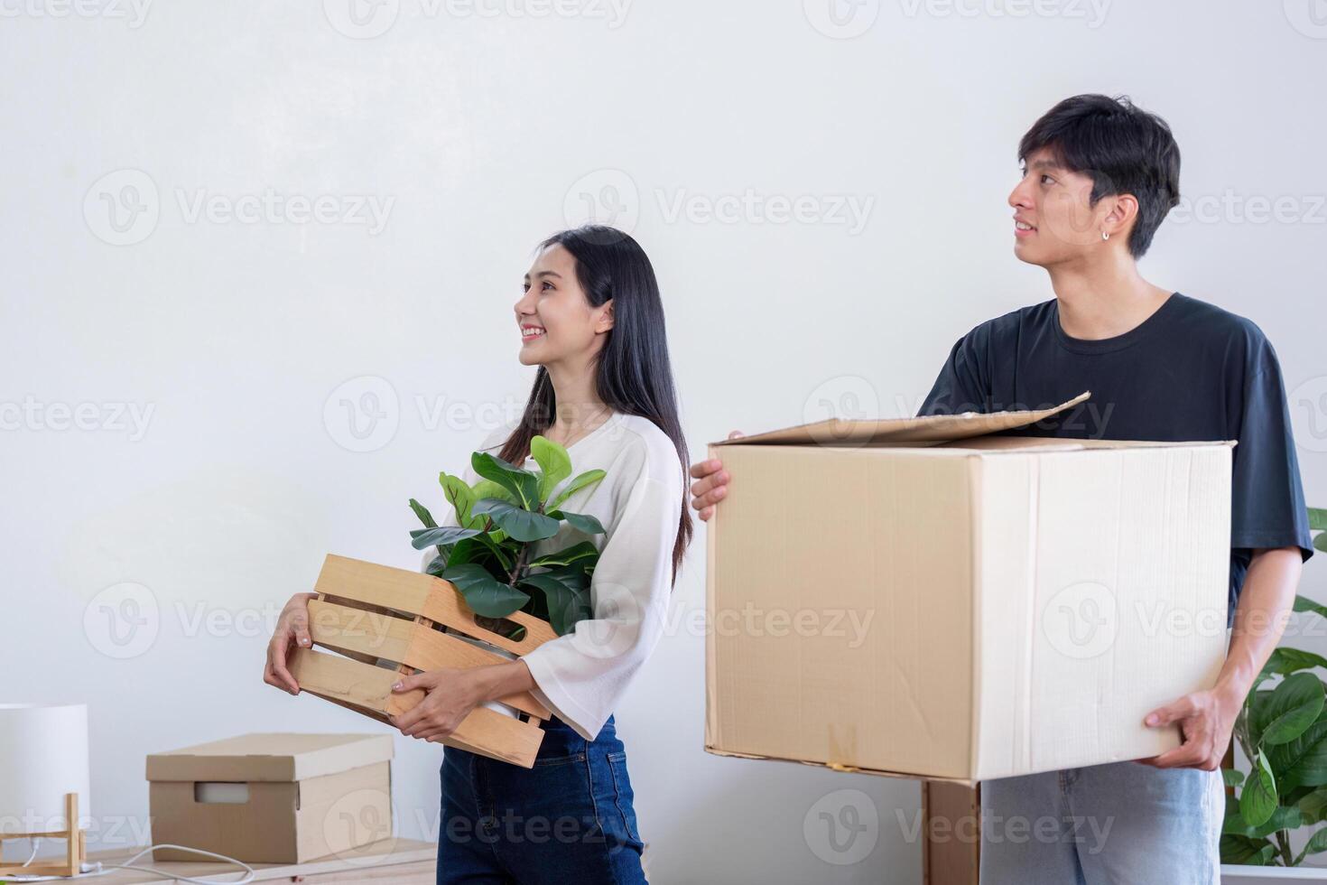 Young Couple Moving into New House, Carrying Boxes and Plants, Starting Fresh in Their Modern Home photo