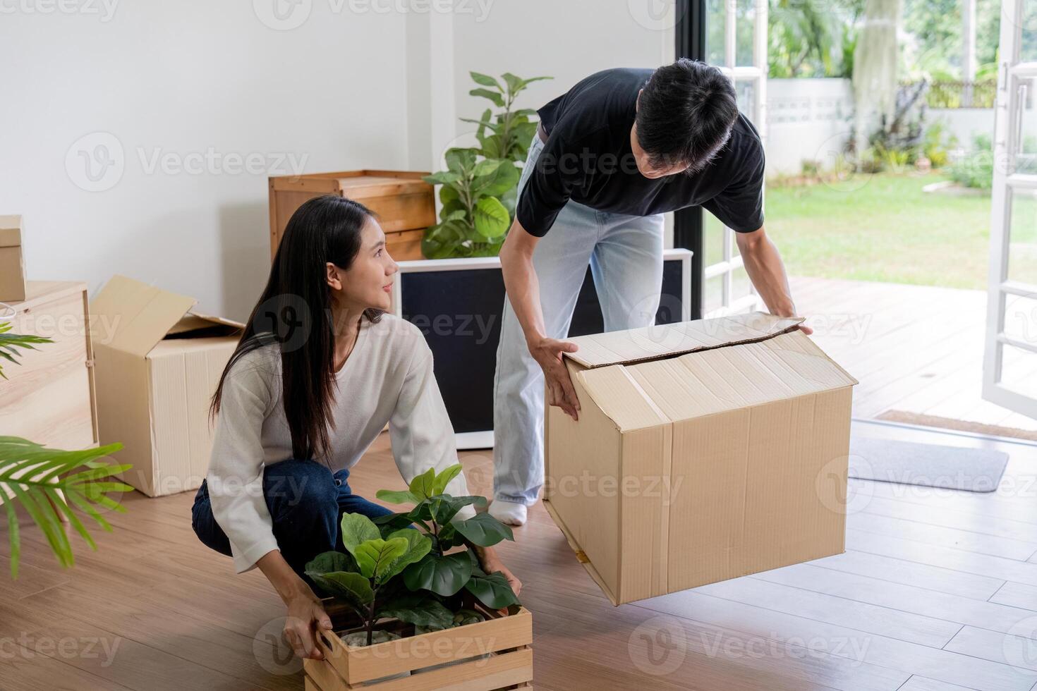 Happy Couple Moving into New House with Boxes and Plants, Starting Fresh in Modern Home photo