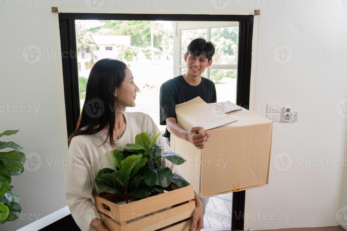 Happy Couple Moving into New House with Boxes and Plants, Starting a New Chapter in Their Lives photo