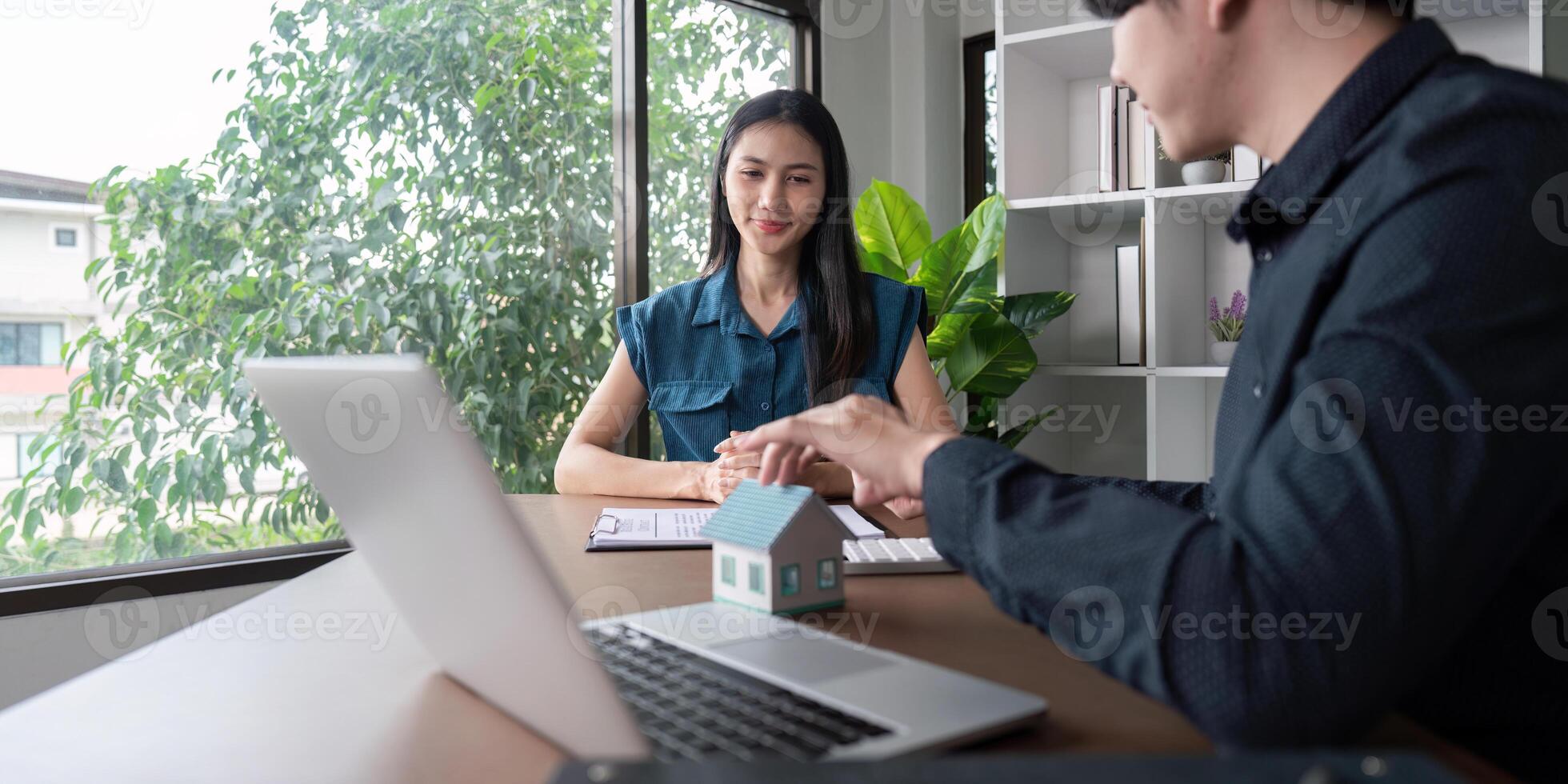 Real Estate Agent and Client Discussing Home Purchase Contract in Modern Office Setting photo