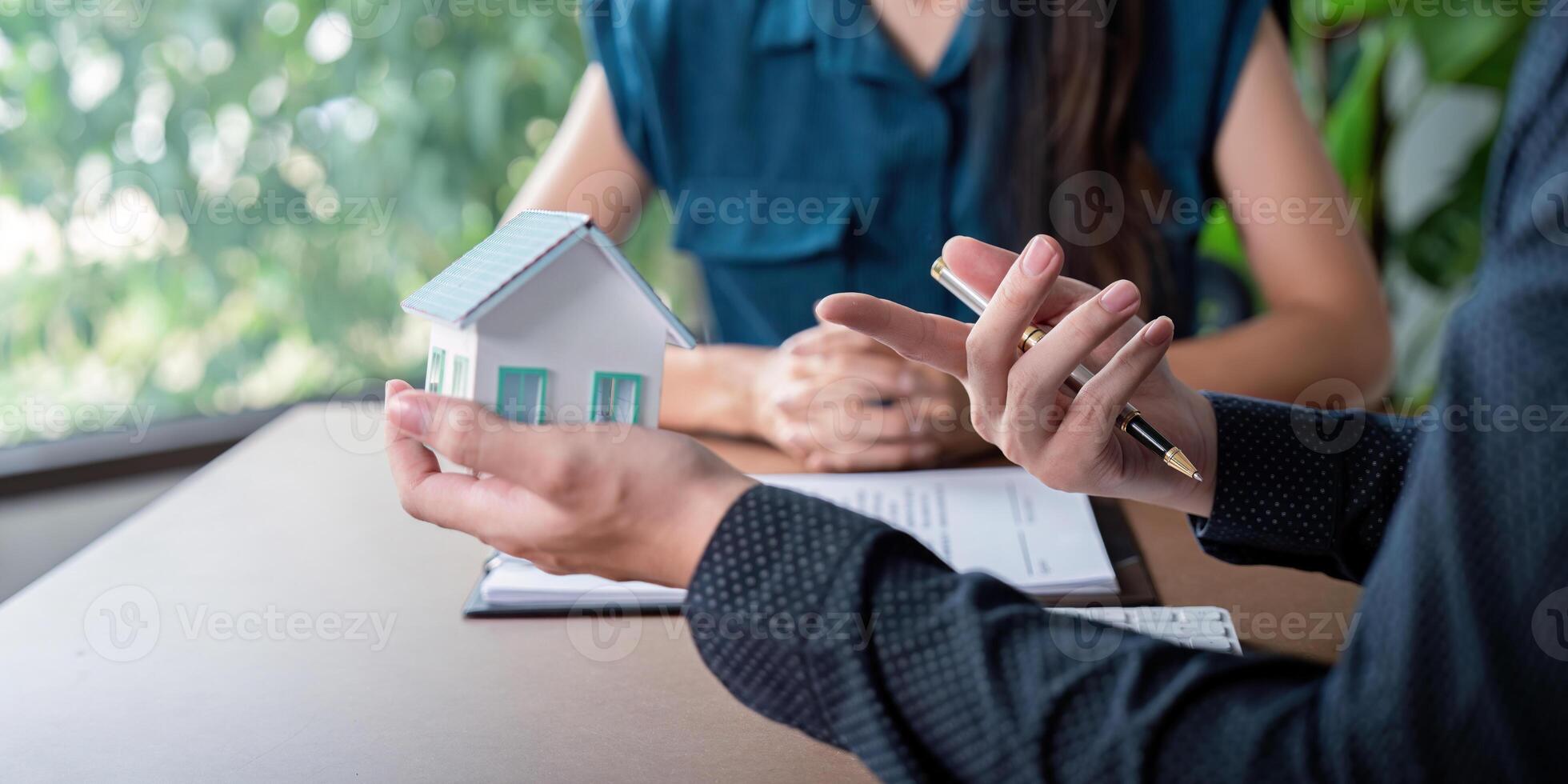 Real Estate Agent Buy Sell Contract Signing with Miniature House Model and Business Professionals photo