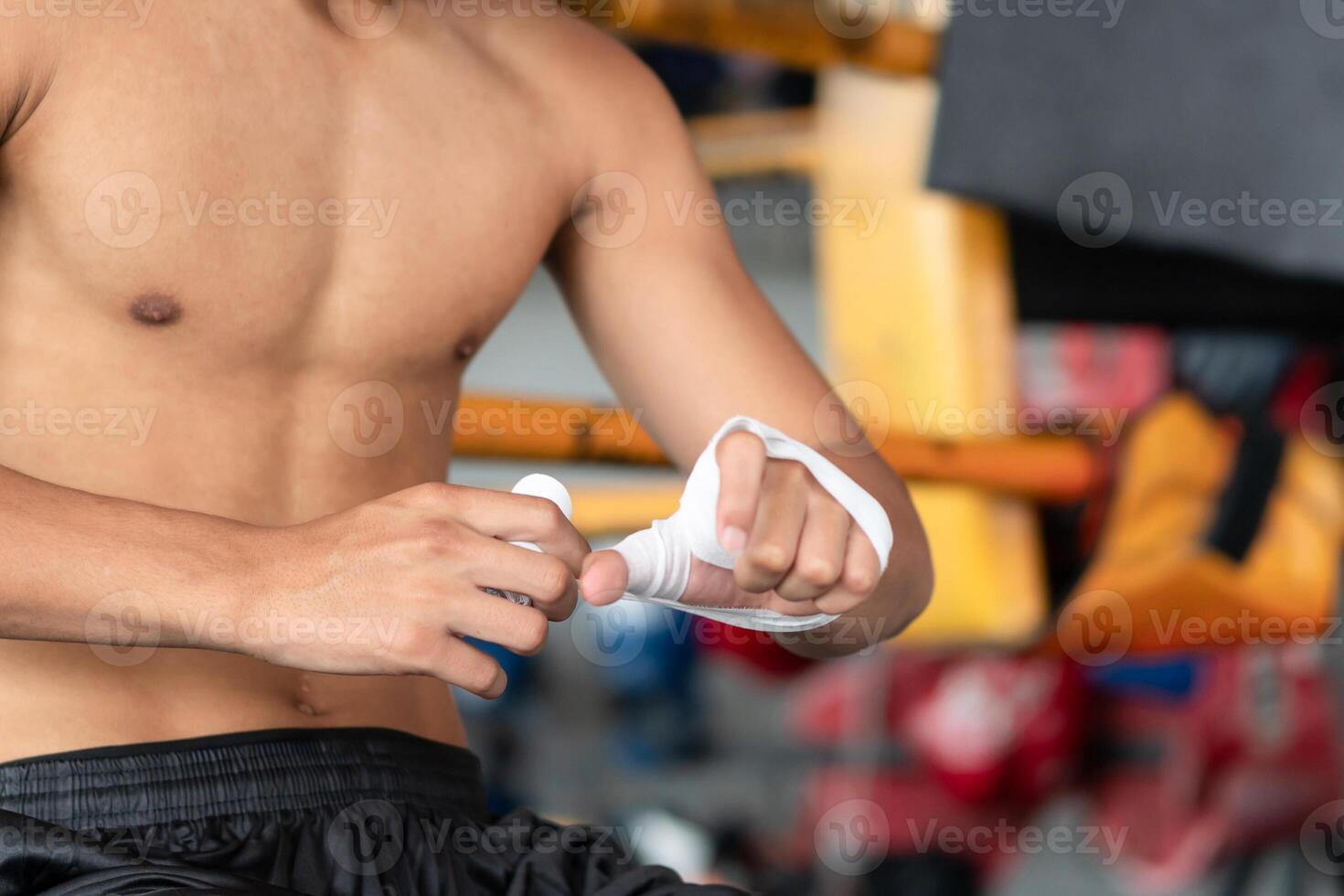 Muay Thai, Male boxer training putting wraps on his hands, Asian fighter is preparing for Thai boxing with bandages wrapped around both hands photo