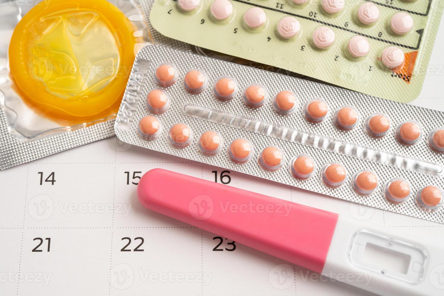 Pregnancy test and birth control pills on calendar, contraception health and medicine. photo