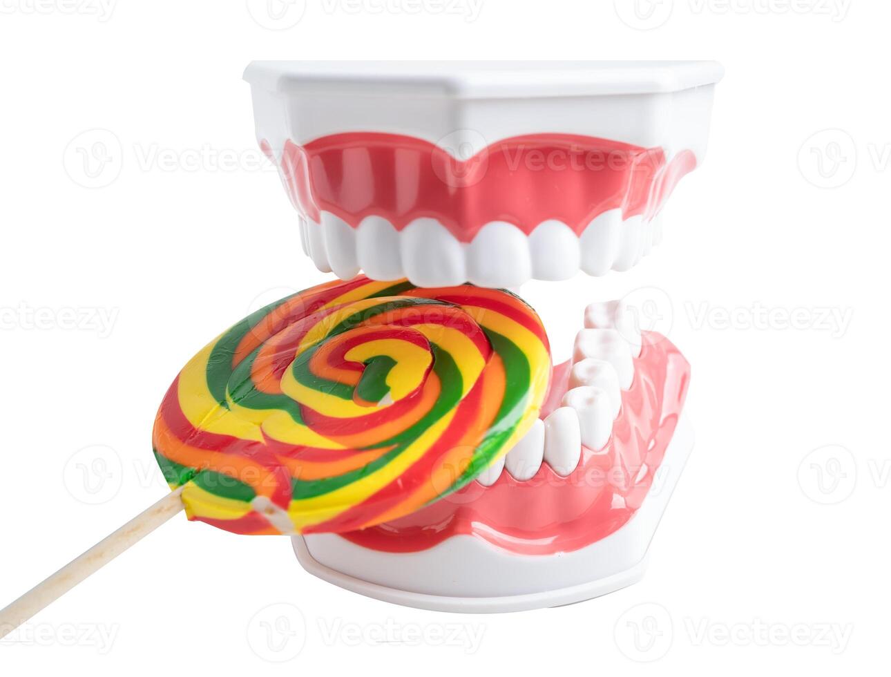 Tooth decay model with colorful candy sweet food on white background with copy space. photo