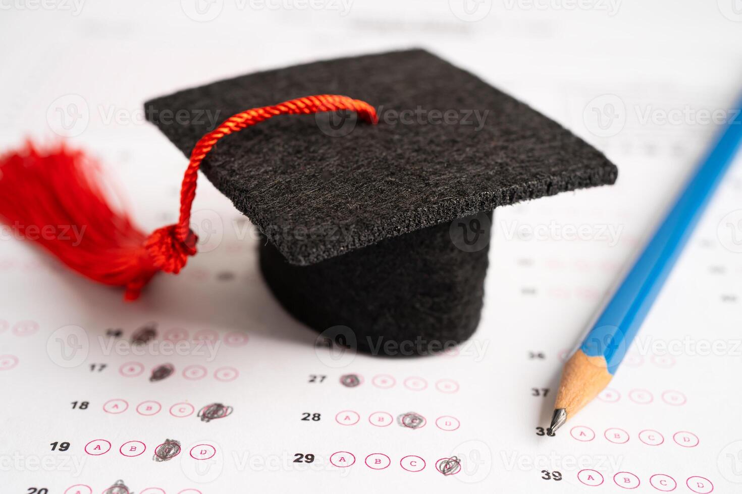Graduation gap hat and pencil on answer sheet background, Education study testing learning teach concept. photo