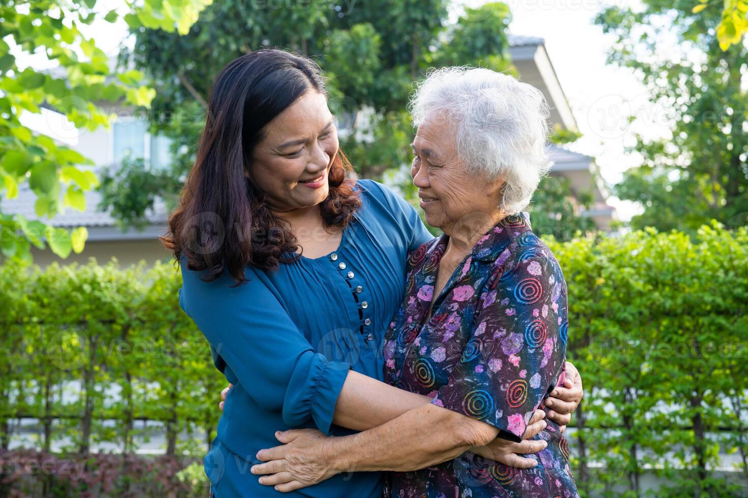 Asian elderly woman hug with her daughter with love, care, help, encourage and empathy at park, healthy strong medical concept. photo